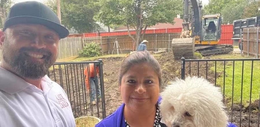 Brandon with a homeowner and her dog beside a pool excavation in progress