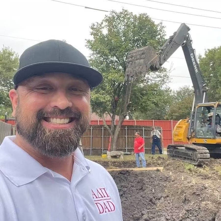 Brandon Woodman on a North Texas job site during excavation, crew and excavator behind him